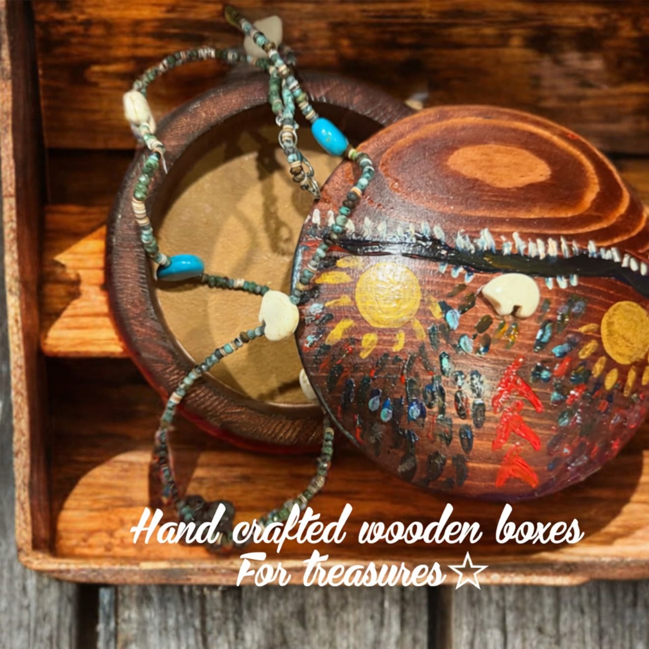 Hand-painted wooden box with colorful folk art and a beaded necklace in a rustic crate.