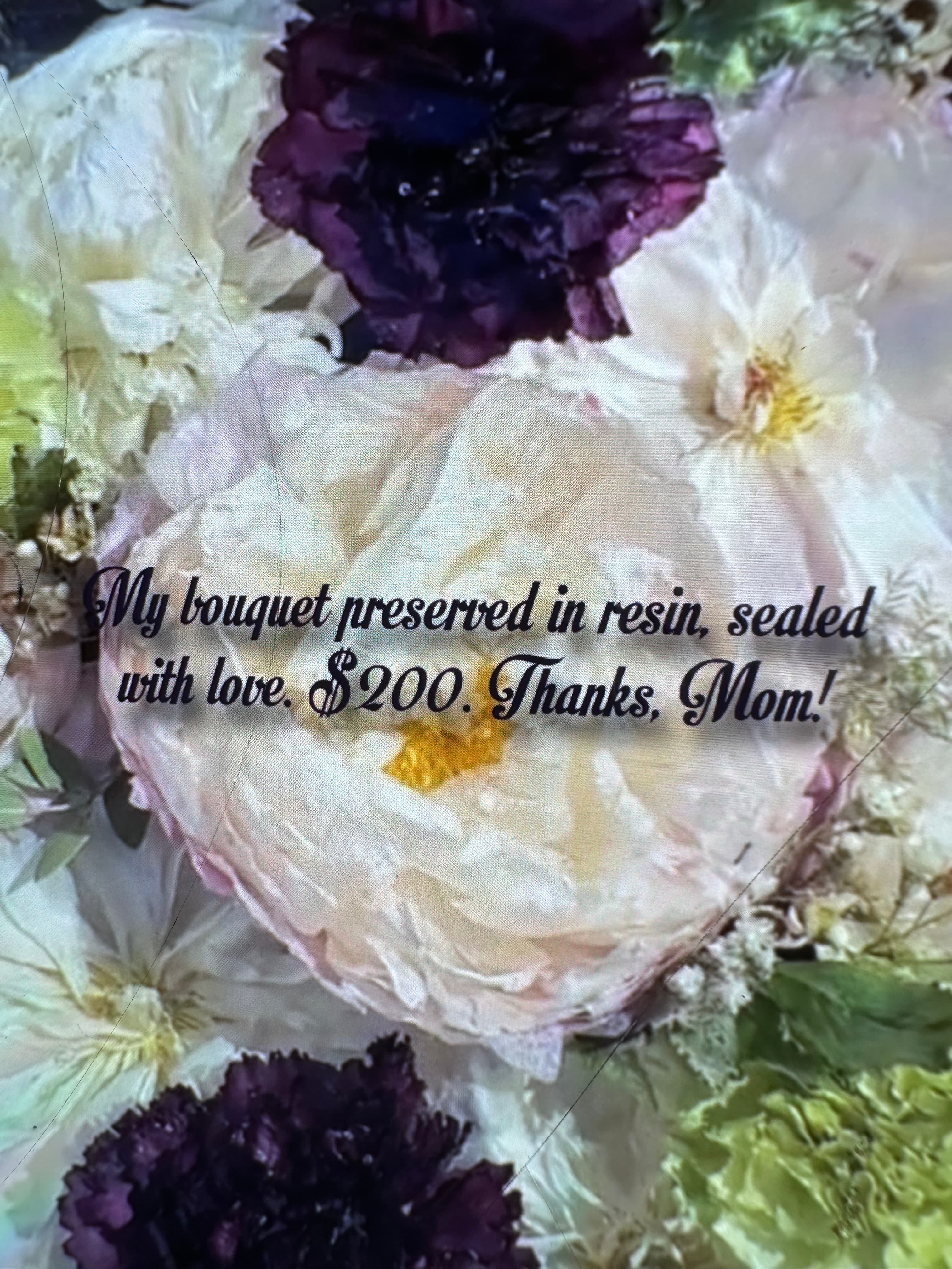 White and purple flowers preserved in resin with text thanking mom for the $200 gift.